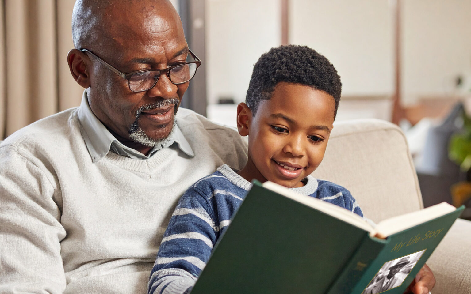 Grandfather and grandson looking at his Life Story hardcover book